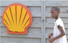  ?? — Reuters ?? A Nigerian schoolboy walks past the logo of Dutch oil giant Shell near Warri in the volatile Niger-delta region.