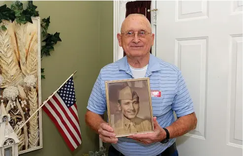  ?? Staff photo by Hunt Mercier ?? Vietnam War veteran Max Taylor poses for a portrait in his Texarkana, Texas, home with a photo of him from his boot camp days. Taylor served in both the U.S. Marine Corps and the U.S. Army.