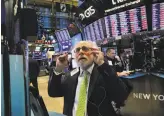  ?? Spencer Platt / Getty Images ?? Traders watch markets slide at the New York Stock Exchange in New York City. Worries about a potential U.S.-China trade war fueled much of the drop.