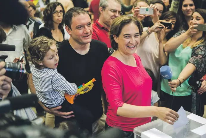  ??  ?? Adrià Alemany sostiene a su hijo Luca mientras su pareja, Ada Colau, votaba el pasado mes de mayo. El resultado de las elecciones la convirtió en alcaldesa de Barcelona