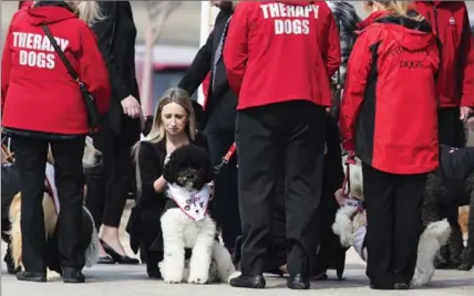  ?? AARON LYNETT, THE CANADIAN PRESS ?? Therapy dogs help mourners after the funeral for seven-year-old Nathan Dumas in Thorold on Friday.