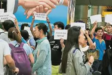  ??  ?? 進行糾察的導遊們高舉­手卡，抗議本地旅行團僱用無­牌中國導遊。