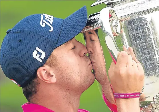  ?? Picture: Getty Images. ?? Justin Thomas plants a kiss on the US PGA silverware after his two-shot victory at Quail Hollow on Sunday.