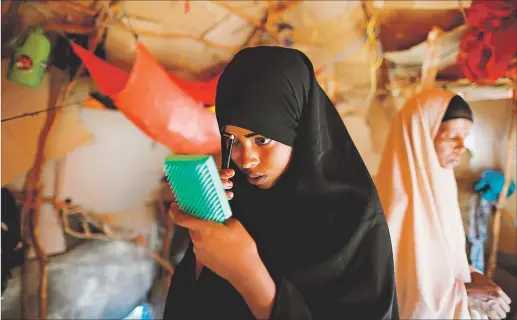  ?? [ Reuters /Zohra Bensemra] ?? Auf der Suche nach Überleben in Würde. Im Lager für intern Vertrieben­e im somalische­n Dollow schminkt sich die 14-jährige Zeinab, bevor sie sich auf den Weg zur Schule macht.
