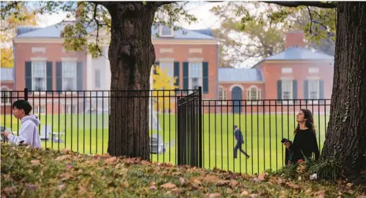  ?? KARL MERTON FERRON/STAFF ?? People walk on Johns Hopkins University’s Homewood campus in November. A year at Hopkins costs just under $63,000 in tuition.