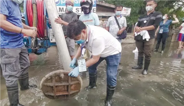  ?? / ALAN TANGCAWAN ?? DECLOGGING. Lapu-Lapu City Mayor Junard Chan visits the floodprone sitios of Tungdon and Tanke in Brgy. Basak, together with the City Disaster Risk Reduction Management Offices of Lapu-Lapu and Mandaue. Chan leads the declogging of the drainage during the visit.