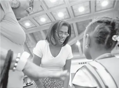  ?? ALGERINA PERNA/BALTIMORE SUN PHOTOS ?? Sonja Santelises, the new Baltimore Schools CEO, center, greets Myaira Jones, 5, at the Community Day & Family EXPO at the Baltimore Convention Center. Jones came with her grandmothe­r, Elaine Ellerby, left.