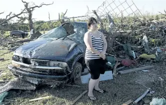  ?? SARAH A. MILLER/THE ASSOCIATED PRESS ?? Kimberly Chandler stands by her destroyed truck and debris from her home in Canton, Texas, on Sunday. Severe weather killed at least 15 people on the weekend.