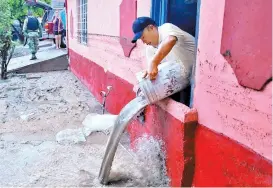  ??  ?? Vecino de la colonia Victoria, Matamoros, saca agua de su casa anegada.