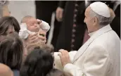  ??  ?? Pope Francis blesses a baby during a meeting with the employees of the Holy See and their families at Paul VI audience hall in Vatican on Sunday. —