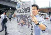  ?? AFP ?? A pedestrian reads Japanese newspaper reporting Osaka’s win.