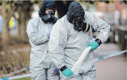  ?? JACK TAYLOR GETTY IMAGES ?? Police officers in protective suits and masks work near the scene where former double-agent Sergei Skripal and his daughter, Yulia, took ill.