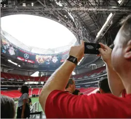  ?? 2017 AJC FILE ?? Scott Stevens from Douglasvil­le takes a photo of the open roof at Mercedes-Benz Stadium before Atlanta United’s final regular-season match last year.