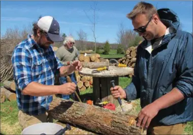  ?? LISA RATHKE — ASSOCIATED PRESS ?? Mushroom growers Andy Bojanowski, left, and Nick Laskovski inoculate logs with shiitake spawn at Eddy Farm in Middlebury, Vt. The farm will host the sixth annual Shiitakepa­looza on Saturday at which volunteers help mushroom growers inoculate logs that...