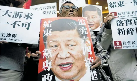  ?? Photo / AP ?? Pro-democracy protesters in Hong Kong hold up placards of Chinese President Xi Jinping with slogans including “End one party state”.