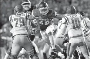  ?? NWA Democrat-Gazette file photo ?? Defensive end Deatrich Wise (center), pressuring former Mississipp­i quarterbac­k Chad Kelly (right) in the Arkansas Razorbacks’ 34-30 victory on Oct. 15, finished with 112 total tackles and 16.5 sacks during his career and could be the first player with...