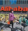  ?? AFP ?? A woman walks past Alibaba’s office in Beijing.