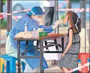  ?? AFP ?? A health worker takes a swab sample from a child to be tested for Covid-19 in Nanning in China’s southern Guangxi region.