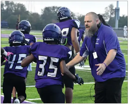  ?? PHOTOS BY DREW ELLIS — THE OAKLAND PRESS ?? Pontiac football coach Ken Wade (right) encourages his team as they take the field for the first time at their new stadium on Friday.