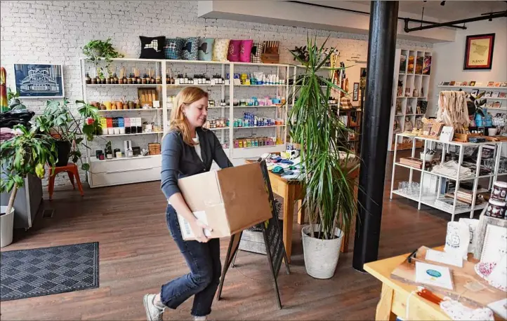  ?? Photos by Will Waldron / Times Union ?? Elizabeth Schanz, assistant manager at Fort Orange General Store in downtown Albany, saw an increase in her hourly rate.