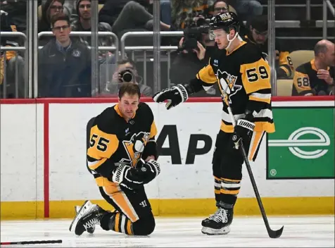  ?? Justin Berl/Getty Images ?? A wobbly Noel Acciari attempts to get to his feet Tuesday after being hit by Winnipeg’s Brenden Dillon at PPG Paints Arena. Jake Guentzel checks on his teammate.