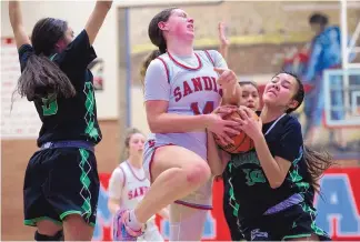  ?? CHANCEY BUSH/JOURNAL ?? Sandia’s Audri Wright, middle, battles for possesion of the ball with Farmington’s Kapiolani Anitielu, right, during Saturday’s game at Sandia High School