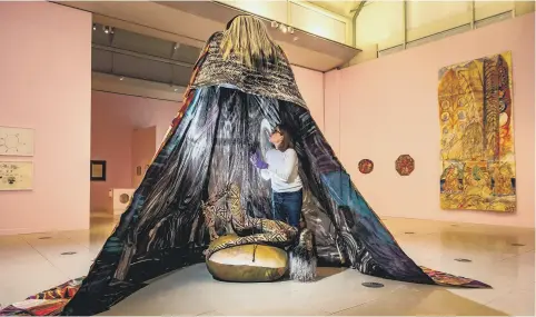  ?? ?? LARGER THAN LIFE: Above, communicat­ions officer Amy Farry looks at Emma Talbot’s acrylic on silk installati­on How is Your Own Death So Inconceiva­ble? at the Millennium Gallery, in Sheffield; inset above, Vidya Gastaldon’s Healing Painting Series is among other artworks on show.