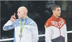  ??  ?? Silver medallist Vassiliy Levit of Kazakhstan reacts to the booing crowd as gold medallist Evgeny Tishchenko of Russia stands at attention for the national anthem. — Reuters photo