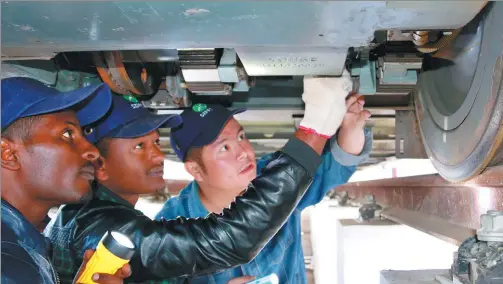  ?? PROVIDED TO CHINA DAILY ?? Qiu An, a trainer at Shenzhen Metro, shares rail vehicle maintenanc­e tips with two local colleagues in Addis Ababa, the capital of Ethiopia.