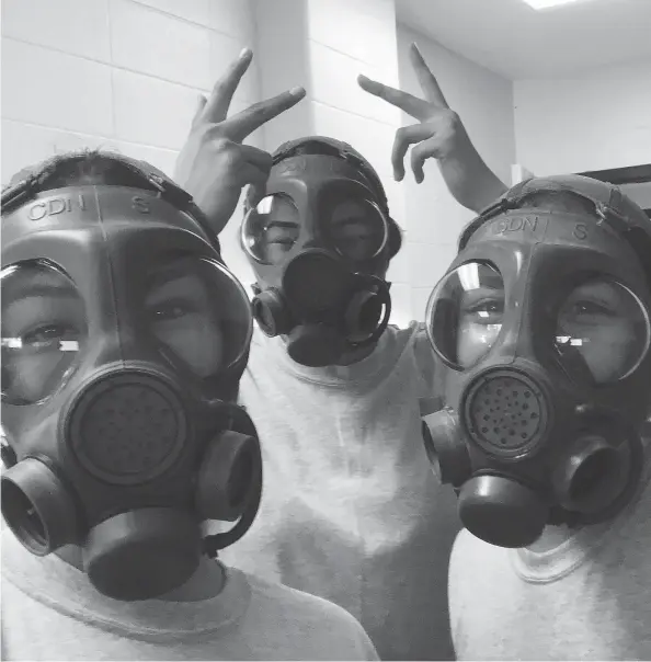  ??  ?? Three camp participan­ts, including Dylan Carrier-henry at left, get fitted for gas masks in preparatio­n for the “gas hut.”