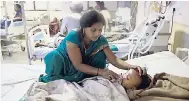  ?? AP ?? A woman attends to a child at Baba Raghav Das Medical College Hospital in the northern Indian state of Uttar Pradesh yesterday.