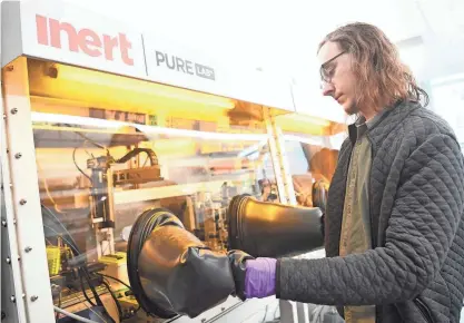  ?? CAITIE MCMEKIN/KNOXVILLE NEWS SENTINEL ?? Spencer Flottman, senior battery scientist, works in a glove box in the Eonix lab at the University of Tennessee at Knoxville. Eonix is using robots and cutting-edge sensors to find better battery materials faster than its competitio­n.