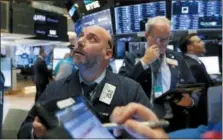  ?? RICHARD DREW — THE ASSOCIATED PRESS ?? Trader Vincent Napolitano, left, works on the floor of the New York Stock Exchange, Friday.