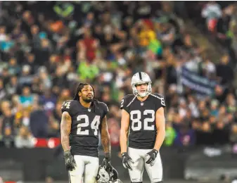  ?? Bettina Hansen / Seattle Times ?? Running back Marshawn Lynch and wide receiver Jordy Nelson watch the scoreboard late in the Raiders’ 27-3 loss to Seattle on Oct. 14 at Wembley Stadium in London.