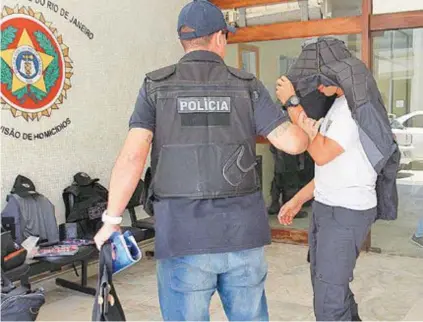  ?? EstEfan Radovicz ?? Um dos policiais presos na operação é levado ainda de farda por agentes da Corregedor­ia da PM