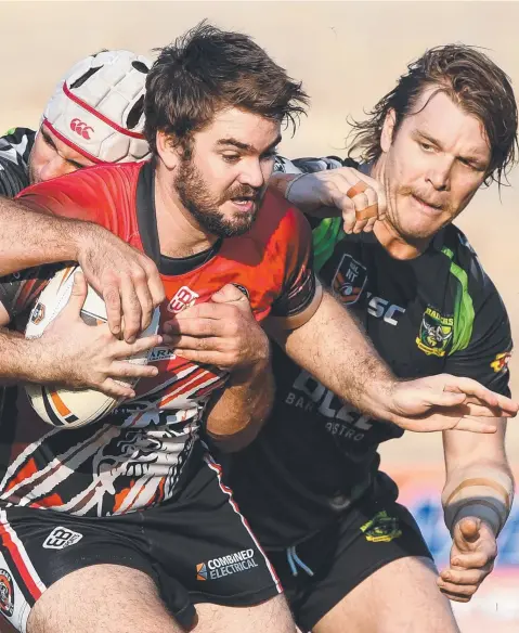  ?? Picture: FELICITY ELLIOTT ?? Jason Tomes of the Litchfield Bears tries to burst through the Palmerston Raiders line as Jerome Edwards and Daniel O'Driscoll attempt to stymie his run during the NRLNT major semi-final at Rugby Park last night