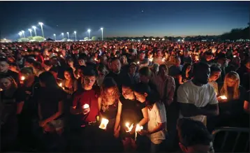  ?? GERALD HERBERT — THE ASSOCIATED PRESS FILE ?? People attend a candleligh­t vigil for the victims of the Wednesday shooting at Marjory Stoneman Douglas High School, in Parkland, Fla., on Feb. 15, 2018.