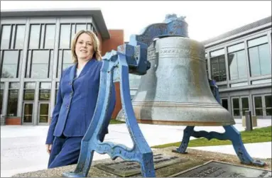  ?? ARNOLD GOLD — NEW HAVEN REGISTER ?? Clinton Superinten­dent of Schools Maryanne O’Donnell is photograph­ed by the original bell from Morgan School near the back entrance to the new Morgan School in Clinton.