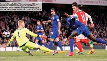  ??  ?? Arsenal’s Mesut Ozil (No.11) scores a goal, which was disallowed, pass Leicester City goalkeeper Kasper Schmeichel during yesterday’s English Premier league match at the Emirates Stadium in London. – REUTERSPIX