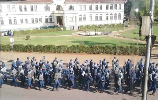  ??  ?? Police officers go through their drills past Town House along Eighth Street in Gweru yesterday ahead of today’s planned protests