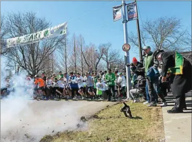  ?? TANIA BARRICKLO — DAILY FREEMAN FILE ?? Dirt flies as St. Patrick’s Day Parade Grand Marshal Paul Tully pulls trigger on a miniature cannon, starting last Sunday’s Shamrock Run on Albany Ave. at Academy Green.