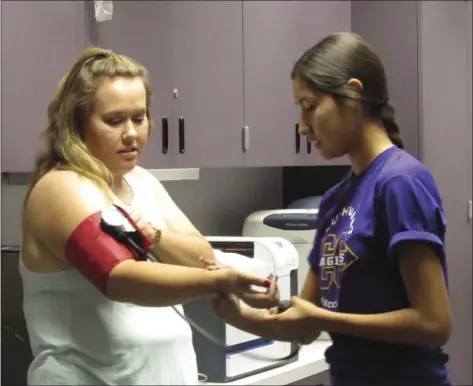  ?? MIGUEL HERRERA PHOTO ?? Madisen Lopez and Iris Valadez practice taking blood pressure during the first responders class at Southwest High School.
