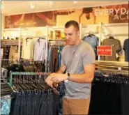  ?? MICHILEA PATTERSON — DIGITAL FIRST MEDIA ?? Justin Meade, manager of the local active wear RBX retail store, hangs clothes. The store was recently opened inside the Philadelph­ia Premium Outlets in Limerick.