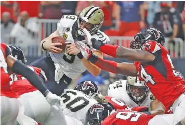  ?? AP PHOTO/MARK HUMPHREY ?? New Orleans Saints quarterbac­k Drew Brees (9) leaps over the goal line for the winning touchdown during Sunday’s 43-37 overtime victory against the host Atlanta Falcons. Brees passed for five touchdowns and ran for two, including the one that set up overtime.