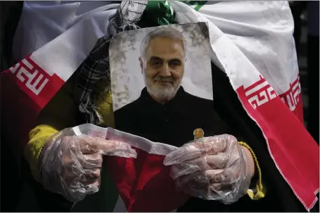  ?? VAHID SALEMI — THE ASSOCIATED PRESS ?? A worshipper holds a portrait of the late Iranian Revolution­ary Guard Gen. Qassem Soleimani, who was killed in a U.S. drone attack in 2020in Iraq, during an anti-Israeli gathering after Friday prayer in Tehran, Iran. An apparent Israeli drone attack on Iran saw troops fire air defenses at a major air base and a nuclear site early Friday morning near the central city of Isfahan, an assault coming in retaliatio­n for Tehran’s unpreceden­ted drone-and-missile assault on the country.