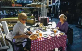  ??  ?? Carol Goedde, left, and Jackie Moncreiff enjoy an outdoor lunch at Maggiano’s Little Italy restaurant in San Jose on Thursday. They say they are not happy with restrictio­ns.