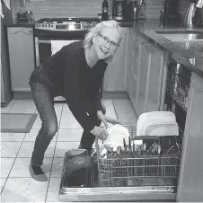  ?? SUPPLIED ?? Bonnie Lindsay demonstrat­es one method for keeping a neutral spine while unloading a dishwasher.