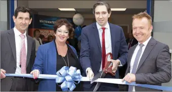  ??  ?? Minister Simon Harris cuts the ribbon on Whitewater’s new premises on the Boghall Road in Bray alongside Tim Quinn, Executive Director, Liz Nangle, Managing Director, and Mark Keating, CEO.