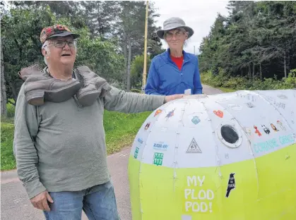  ?? ERIC MCCARTHY/JOURNAL PIONEER ?? Henry Gallant, left, who walked across Canada as a centennial adventure 52 years ago, welcomes Richard Zier-Vogel to his Nail Pond, P.E.I. home. Zier-Vogel is nearing the end of his cross-Canada walk. Gallant, displaying the cap and hiking boots he used in his subsequent walk across Europe, did his centennial walk in hiking boots and carrying a 25-Kg pack while Zier-Vogel is doing it in running shoes and pulling a 75-Kg plod pod he built.