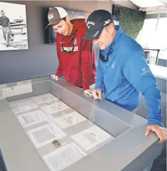  ?? REINHOLD MATAY, USA TODAY SPORTS ?? Austin Man, left, and father Bill Man view letters to and from Arnold Palmer displayed at the Arnold Palmer Invitation­al.